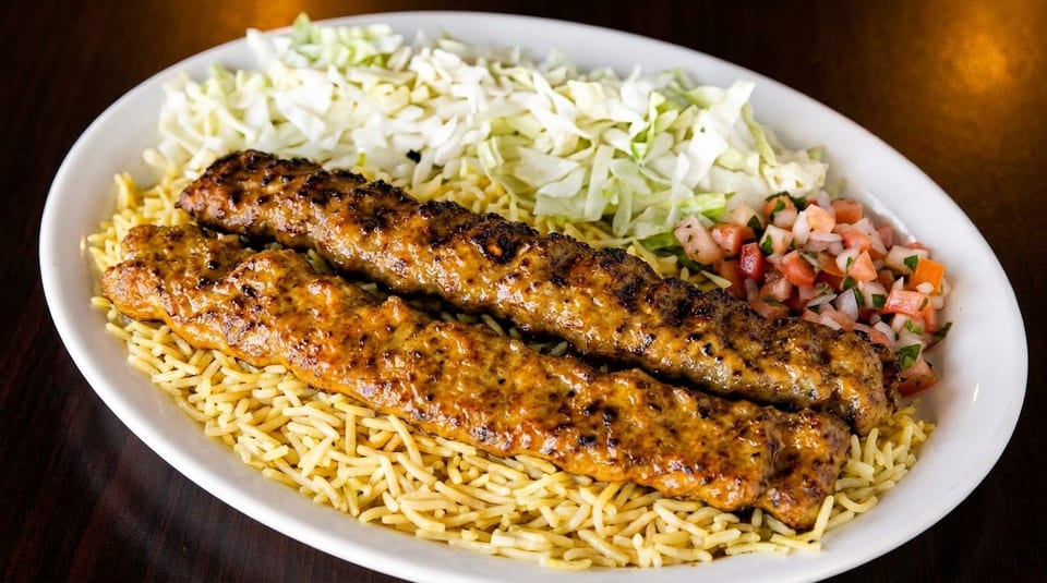 Two grilled meat skewers on a bed of rice, with shredded cabbage and tomato salsa.